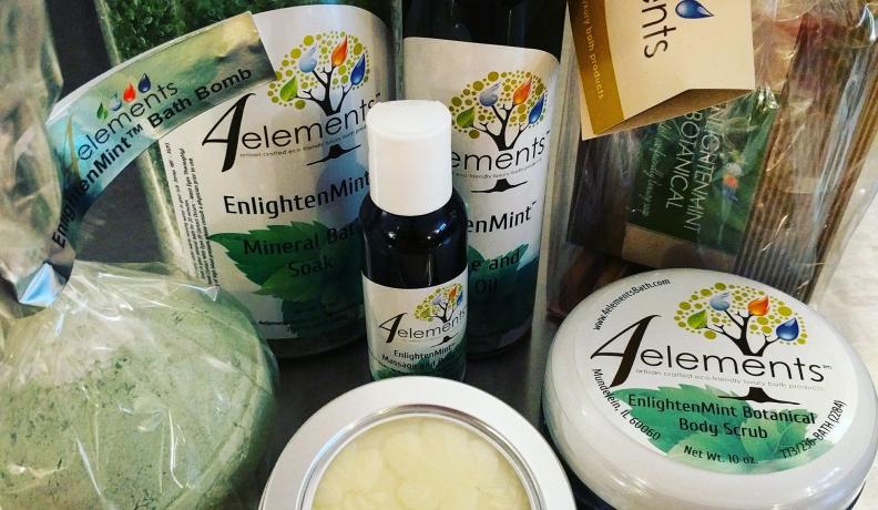 Various mint bath products, including a bath bomb, body scrub in a round tub, and more.