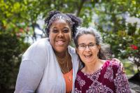 Dr. Lakeisha Thorpe, a Black woman, wears a light grey cardigan over a peach colored shirt. She stands next to Fran Teplitz, retiring co-executive director of Green America, a white woman with greying hair, glasses, in a burgundy floral top.