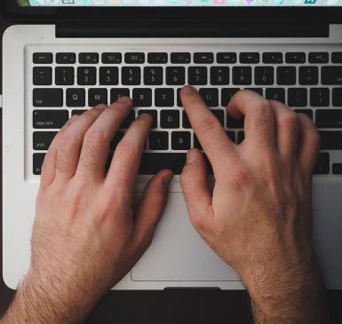 hands typing on laptop