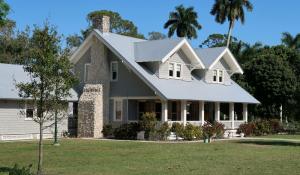 a gray suburban style house with a green yard.