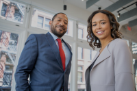 black man and black woman in business attire looking at the camera