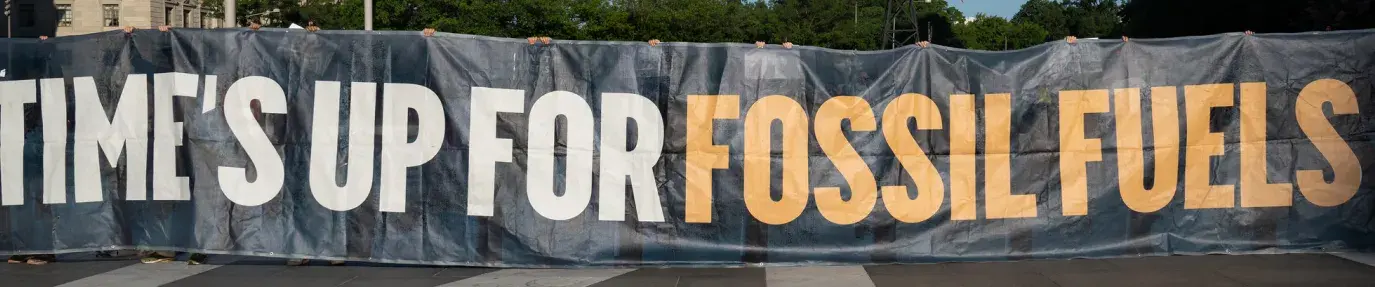 The 2021 J30 climate protest in Washington, DC. Groups gather with a sign that read "time's up for fossil fuels," protesting things like anti-ESG bills.
