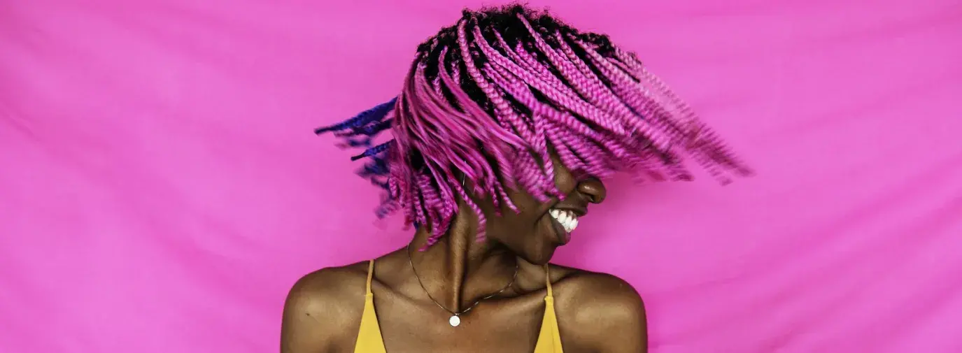 girl shaking her pink hair in front of a pink background