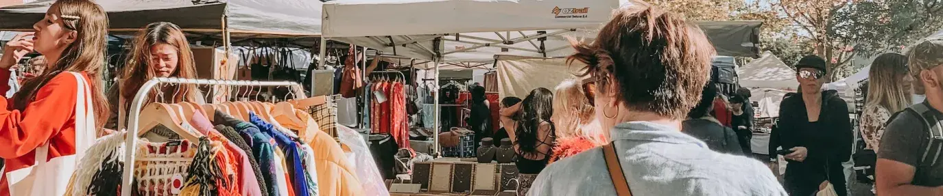 People shopping at a local, outdoor market. Ethical shopping resolutions.