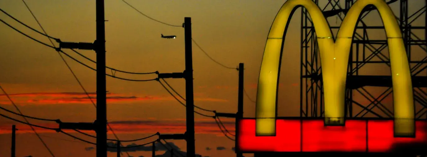 A McDonalds restaurant drivethru sign at dusk.