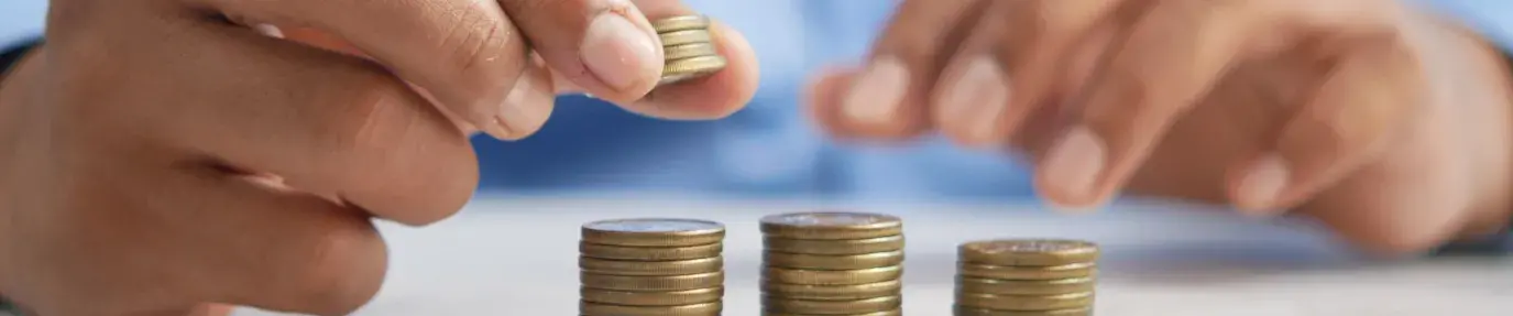 Image: person stacking gold coins. Title: New Green Bond Makes It Easy to Invest in Climate Action